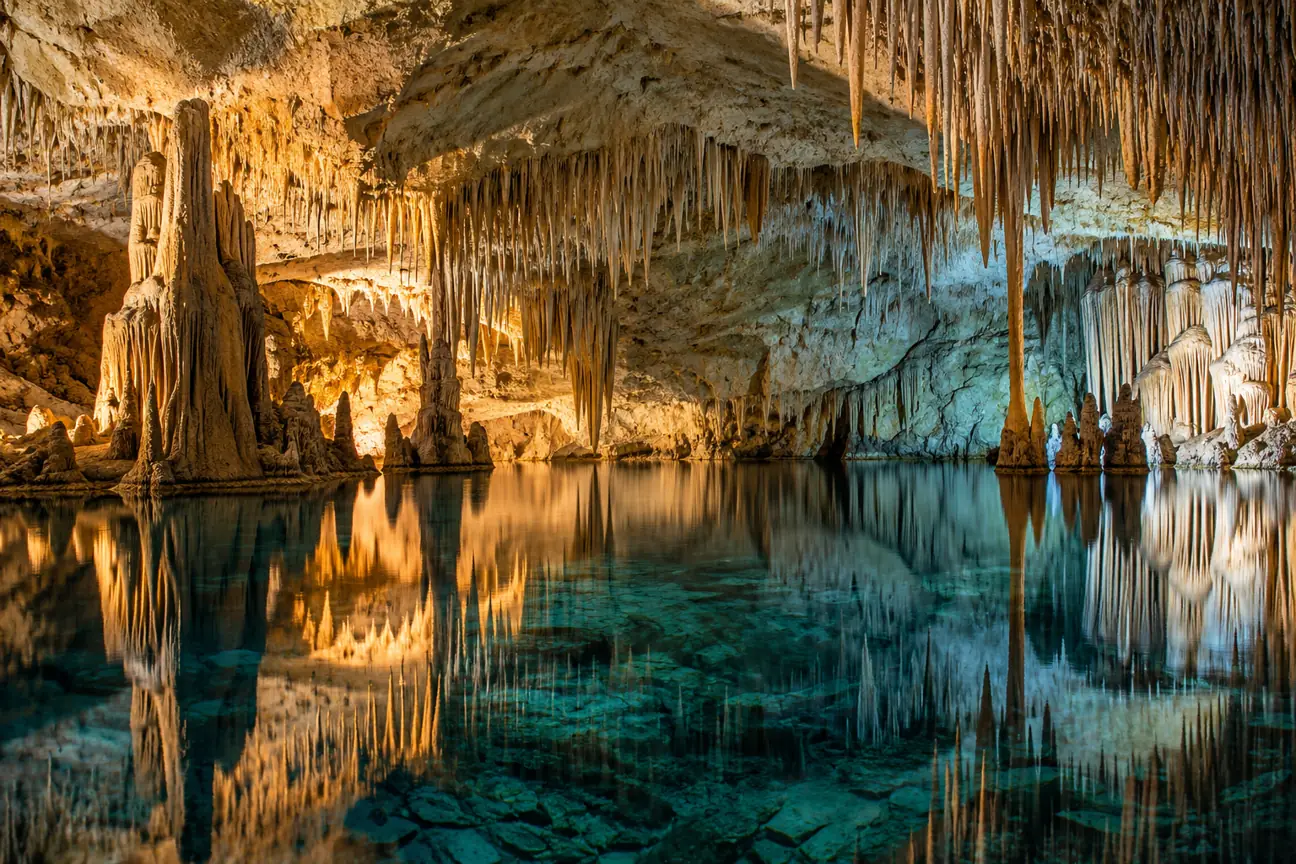 Osvětlené krápníky a podzemní jezero v jeskyni na Mallorce – AI ilustrační fotografie